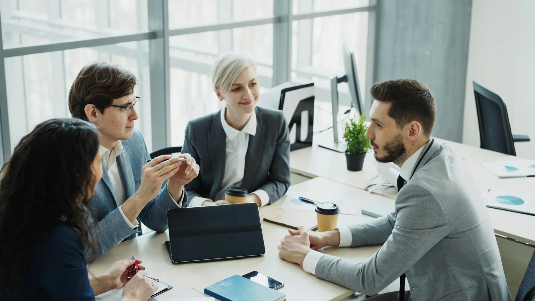 A professional team collaborating around a table in a bright office